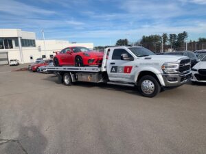 ASI Collision Tow truck hauling a red Porsche away