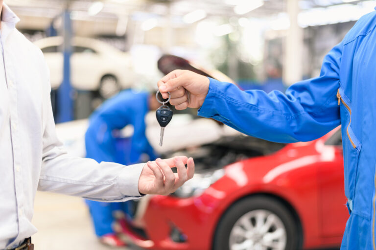 Someone handing their car keys over to an auto body shop