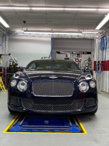 Navy blue Bentley luxury car in repair shop
